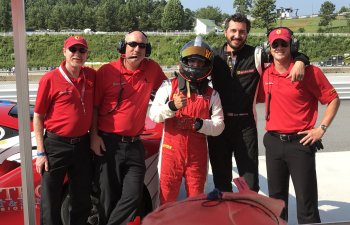 A SuperSpeed Motorsports team standing between Ferrari cars